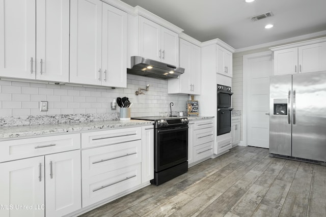 kitchen featuring visible vents, range with electric stovetop, stainless steel refrigerator with ice dispenser, under cabinet range hood, and dobule oven black