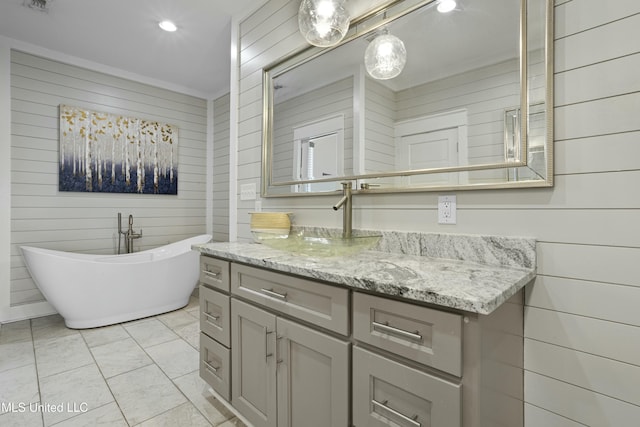 full bath featuring recessed lighting, a freestanding tub, wooden walls, and vanity