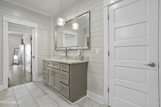 bathroom featuring wooden walls and vanity