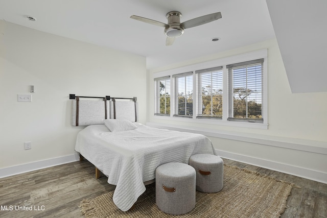 bedroom featuring ceiling fan, baseboards, and wood finished floors