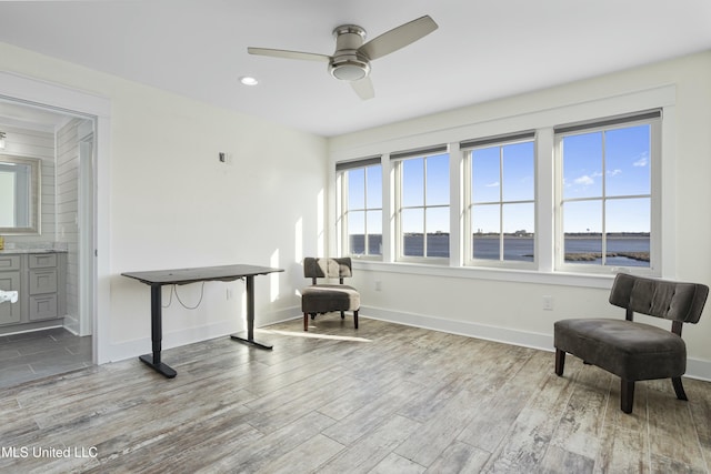 sitting room featuring ceiling fan, baseboards, and wood finished floors