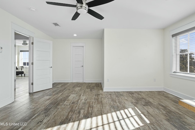 spare room featuring visible vents, wood finished floors, and baseboards