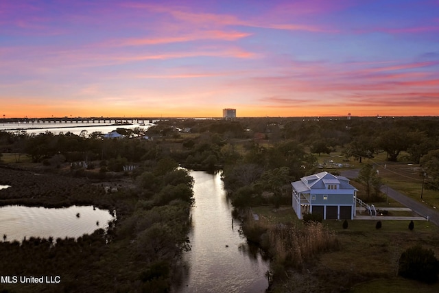 aerial view at dusk featuring a water view