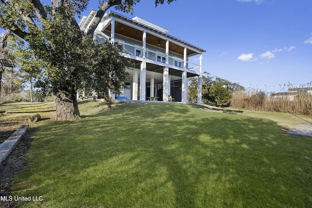 rear view of house featuring a lawn and ceiling fan