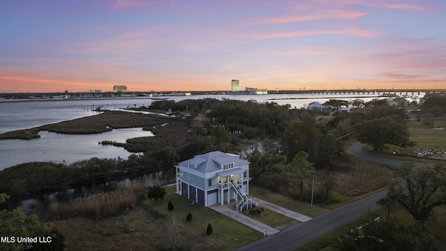 aerial view at dusk featuring a water view