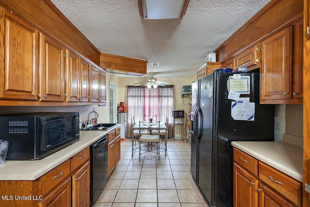 kitchen featuring light tile patterned flooring, sink, a textured ceiling, ceiling fan, and black appliances