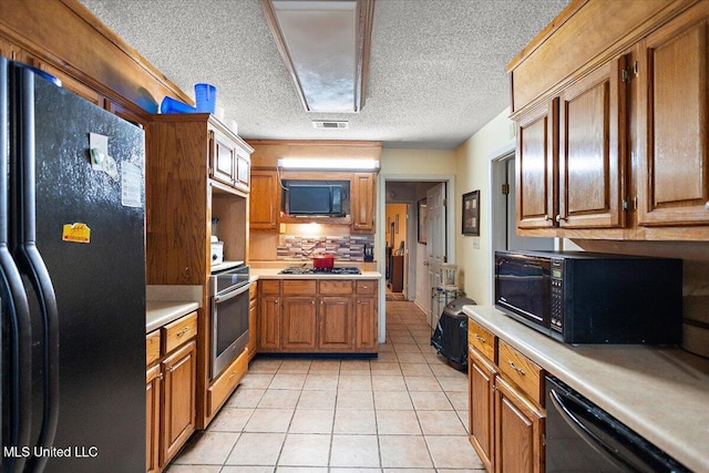 kitchen with light tile patterned floors, decorative backsplash, a textured ceiling, and black appliances