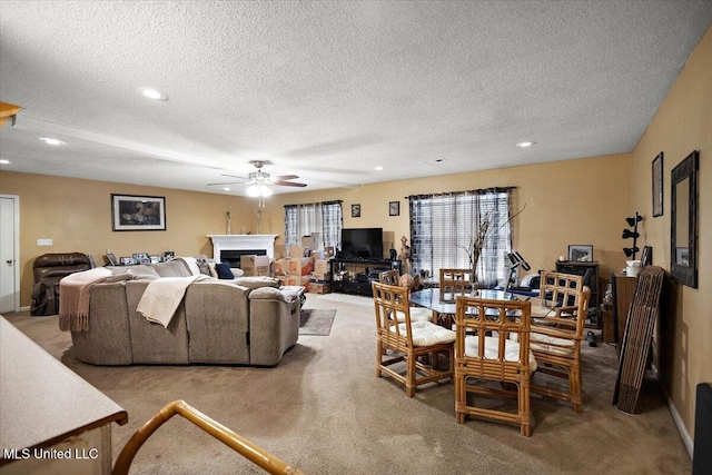 living room featuring ceiling fan, light carpet, and a textured ceiling