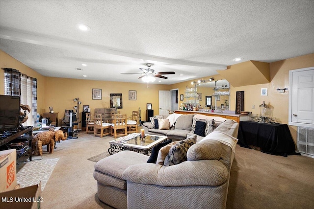 carpeted living room with ceiling fan and a textured ceiling