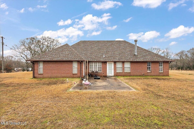 rear view of property with a lawn and a patio