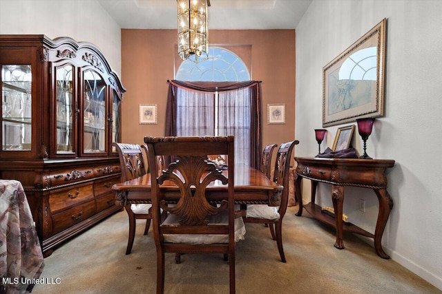 dining area featuring a chandelier and light carpet