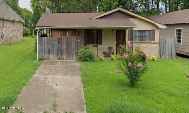 bungalow-style home with brick siding and a front yard