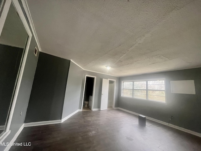 1289 S St, Grenada, MS 38901 - spare room featuring a textured ceiling, crown molding, baseboards, and dark wood-style flooring