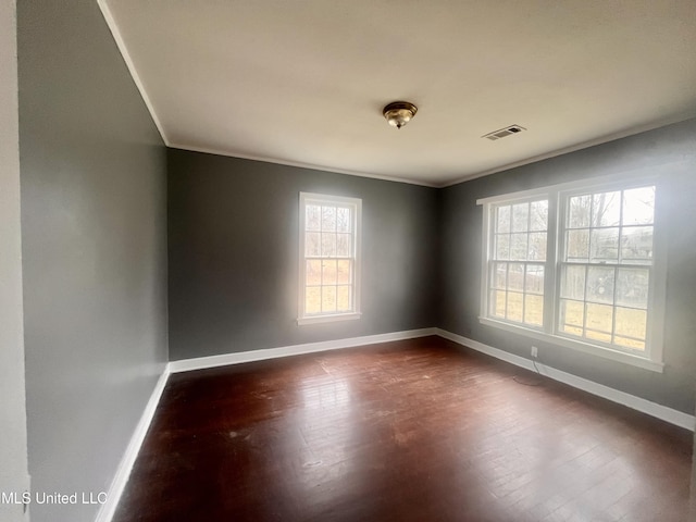 1289 S St, Grenada, MS 38901 - unfurnished room featuring visible vents, baseboards, dark wood-style flooring, and crown molding