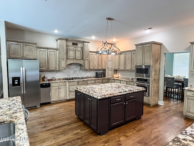 kitchen featuring a center island, hanging light fixtures, stainless steel appliances, an inviting chandelier, and dark hardwood / wood-style floors