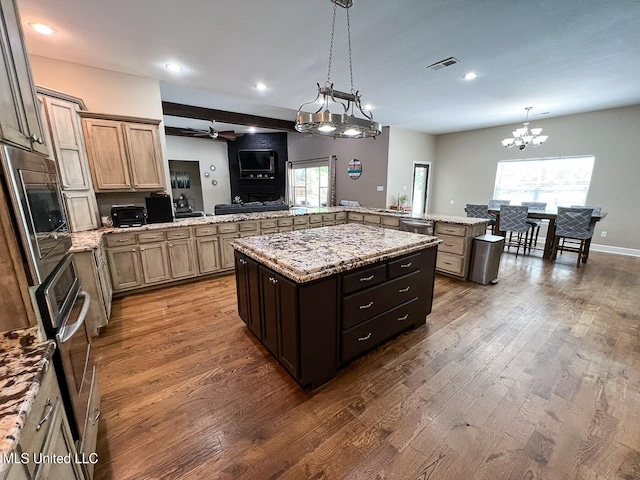 kitchen with kitchen peninsula, dark hardwood / wood-style floors, and a center island