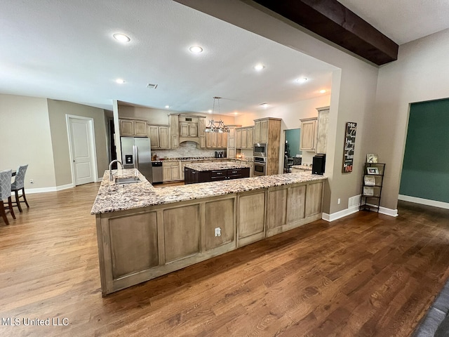 kitchen featuring kitchen peninsula, dark hardwood / wood-style floors, stainless steel appliances, and sink