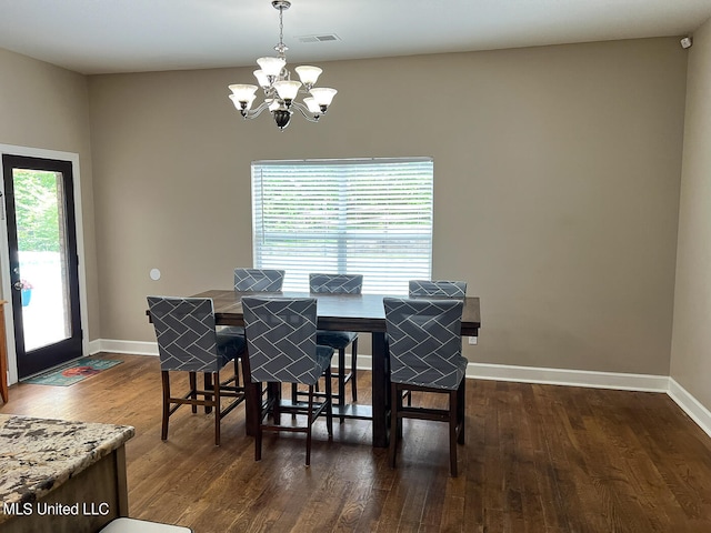 dining room with an inviting chandelier, a healthy amount of sunlight, and dark hardwood / wood-style flooring