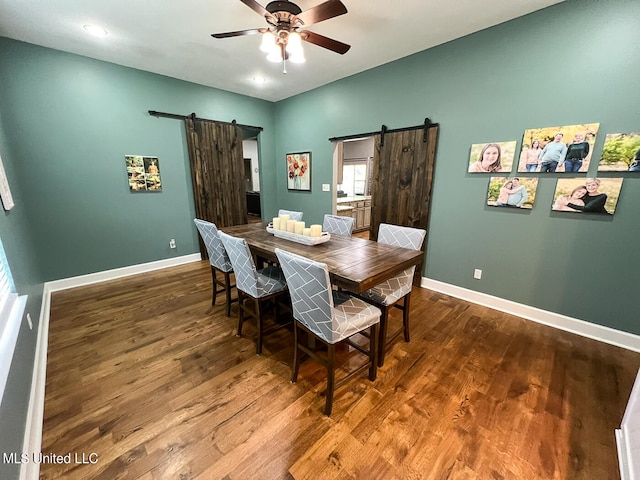 dining area featuring ceiling fan, a barn door, and hardwood / wood-style floors