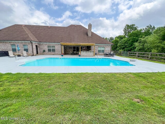 view of pool featuring a patio, a yard, and a diving board