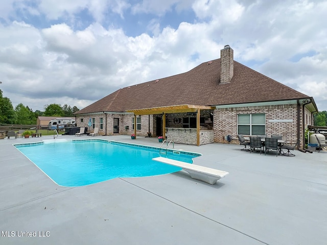 view of pool featuring a patio area and a diving board