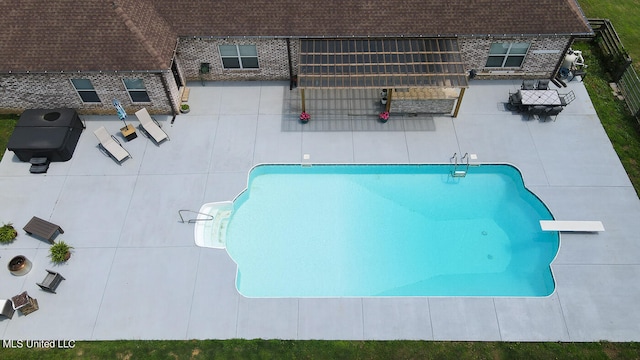 view of swimming pool featuring a diving board and a patio area