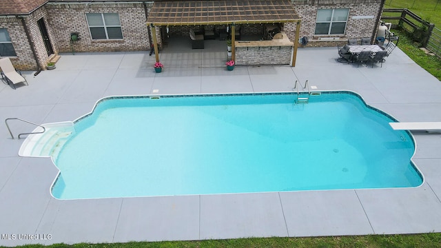 view of pool featuring a patio and a diving board