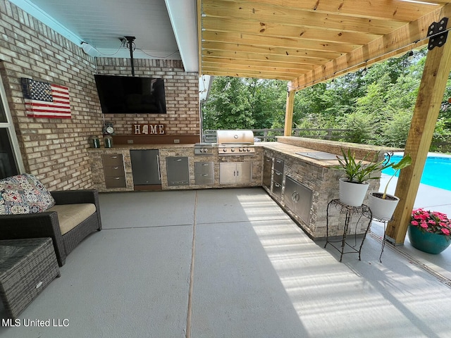 view of patio with an outdoor kitchen, a swimming pool, grilling area, and ceiling fan