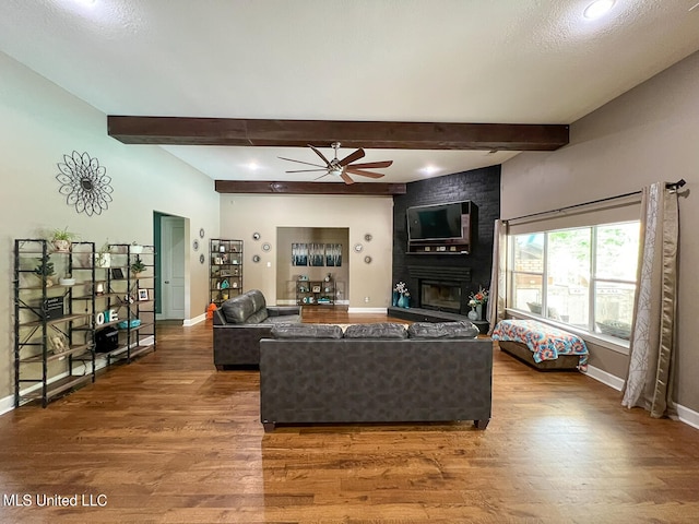 living room with wood-type flooring, a fireplace, and ceiling fan