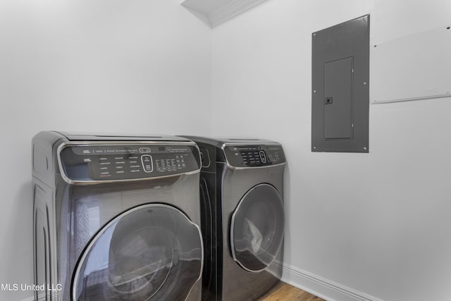 10186 Wire Rd, Vancleave, MS 39565 - clothes washing area featuring electric panel, washing machine and dryer, baseboards, ornamental molding, and wood finished floors
