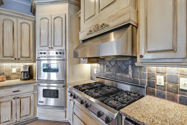 105 Victoria Pl, Madison, MS 39110 - kitchen with appliances with stainless steel finishes, decorative backsplash, ventilation hood, and cream cabinets