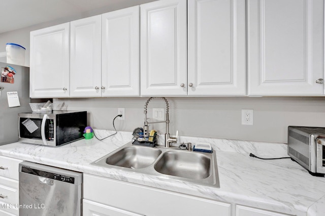 kitchen featuring stainless steel appliances, sink, white cabinets, and light stone counters