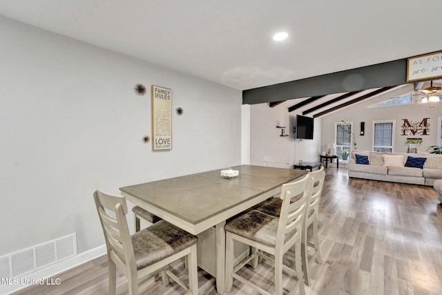 dining space with lofted ceiling with beams, ceiling fan, and light hardwood / wood-style flooring