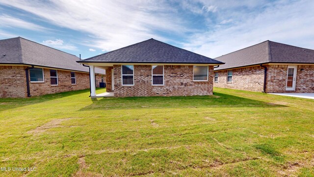 7908 Gardendale Dr, Olive Branch, MS 38654 - back of house featuring brick siding, a lawn, and a patio area