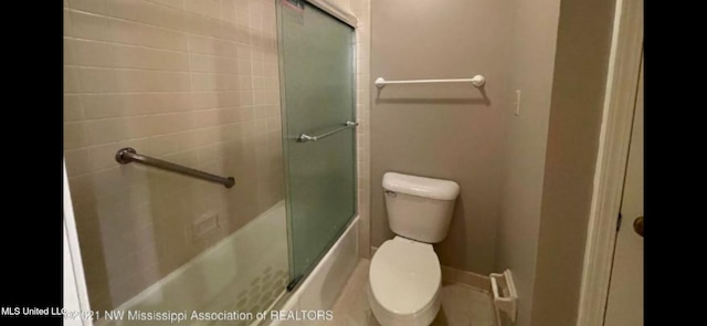 bathroom featuring toilet and combined bath / shower with glass door