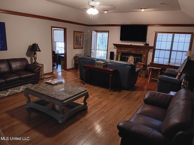 living room featuring ornamental molding, wood-type flooring, and ceiling fan