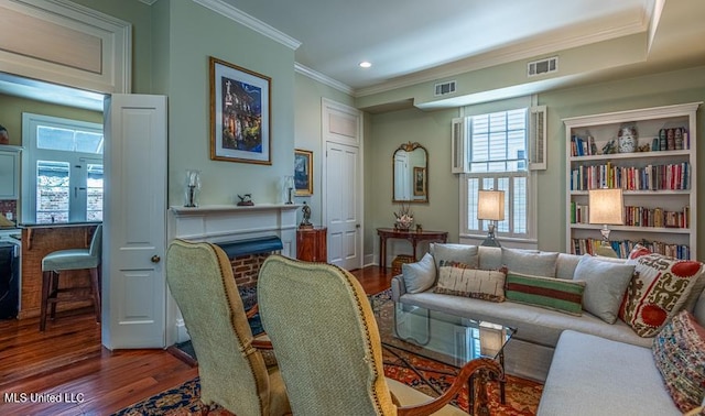 living room featuring a healthy amount of sunlight, ornamental molding, and dark wood-type flooring