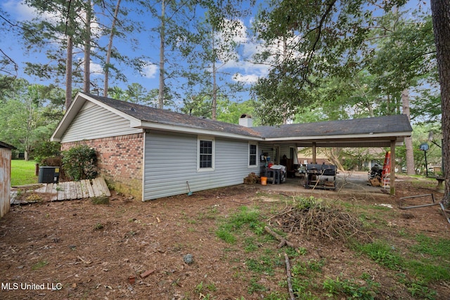 108 Fairdale Pl, Brandon, MS 39042 - back of house featuring a carport, a patio, brick siding, and a chimney