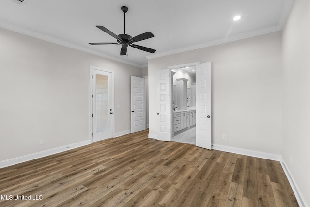 unfurnished bedroom with connected bathroom, hardwood / wood-style flooring, ornamental molding, and ceiling fan