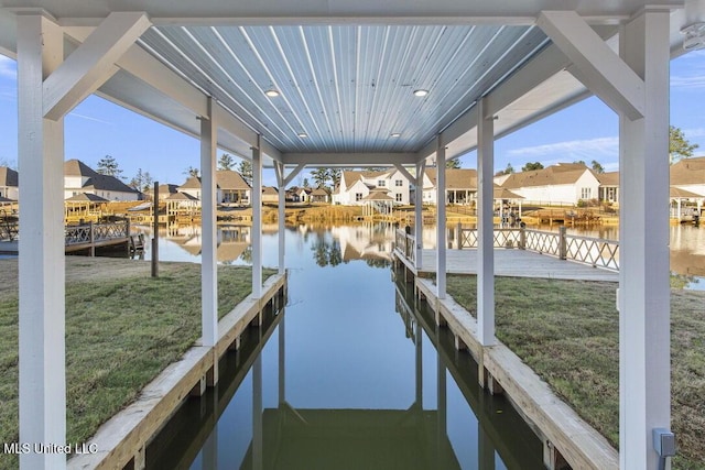 dock area featuring a water view and a lawn