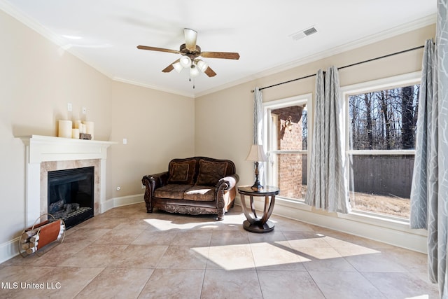 sitting room featuring light tile patterned flooring, a tile fireplace, visible vents, baseboards, and crown molding