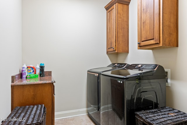 laundry area with baseboards, cabinet space, and washing machine and clothes dryer