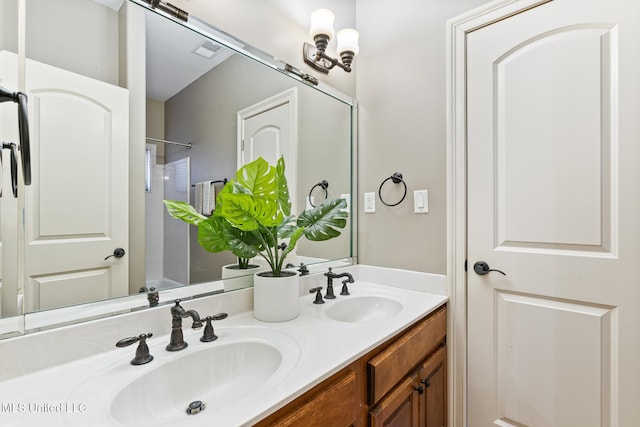 full bathroom with double vanity, visible vents, walk in shower, and a sink