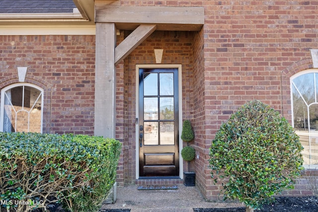 property entrance with brick siding and roof with shingles