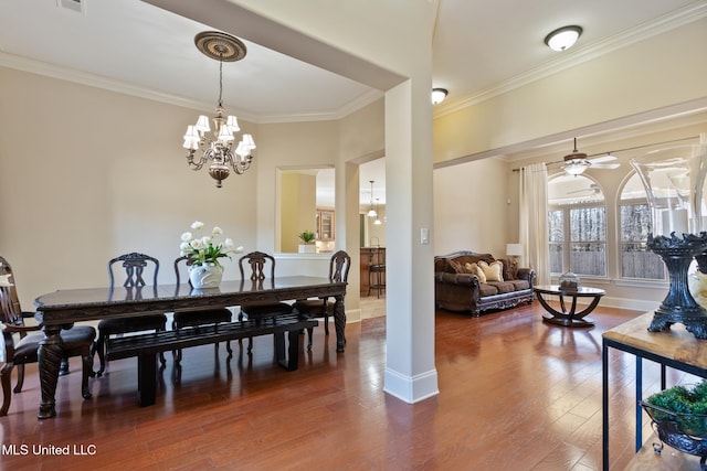 dining room featuring ceiling fan with notable chandelier, baseboards, wood finished floors, and crown molding