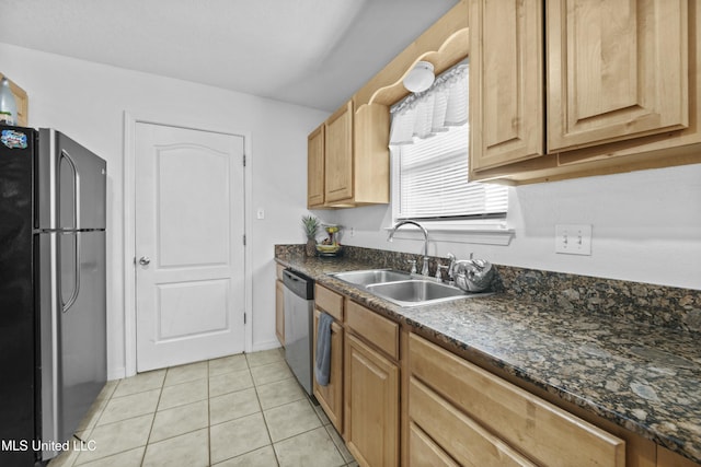 kitchen featuring sink, light tile patterned floors, dark stone counters, and appliances with stainless steel finishes