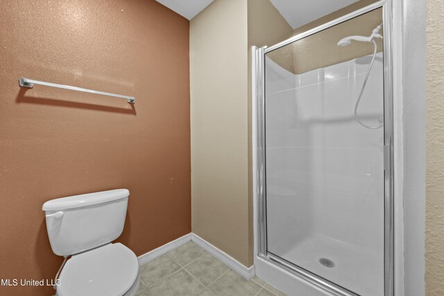 bathroom featuring toilet, an enclosed shower, and tile patterned flooring