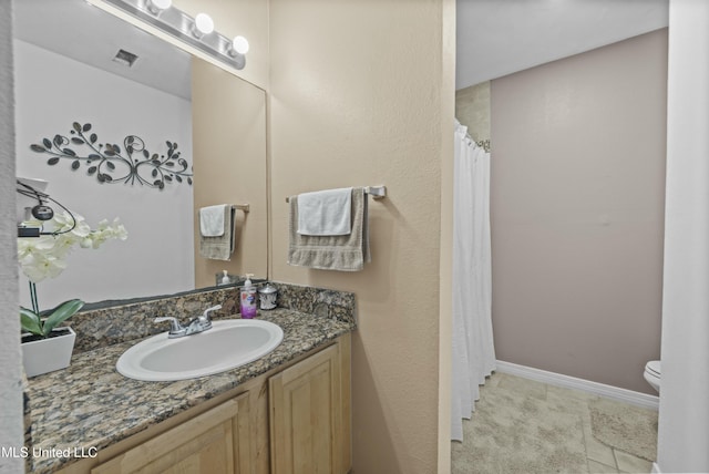 bathroom with tile patterned floors, vanity, and toilet