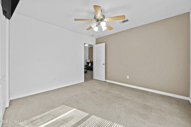 spare room featuring ceiling fan and light colored carpet