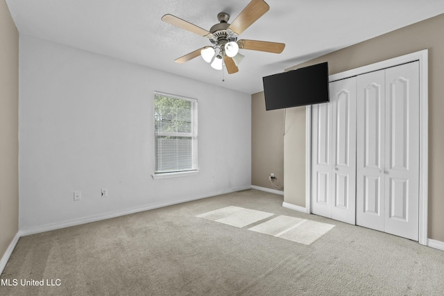 unfurnished bedroom with light carpet, a closet, and ceiling fan